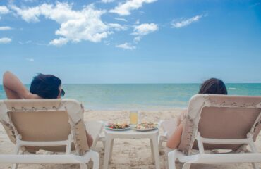 Secluded tropical beach with crystal-clear turquoise ocean and palm trees, perfect for a romantic couple's getaway in Belize.