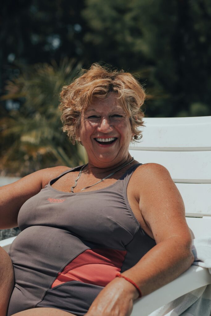 Happy woman smiling while relaxing on a sun lounger during a luxury Mother's Day retreat in Belize.